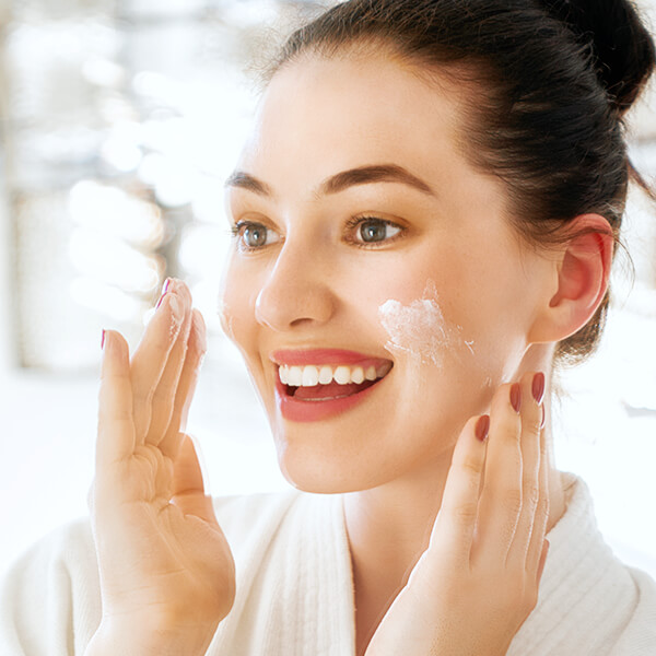 woman applying Hyalogic hyaluronic acid product to her face
