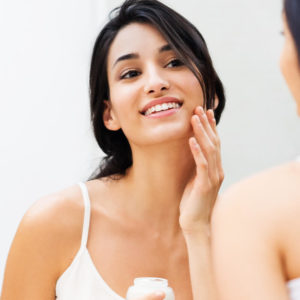 woman applying Hyalogic hyaluronic acid product to her face